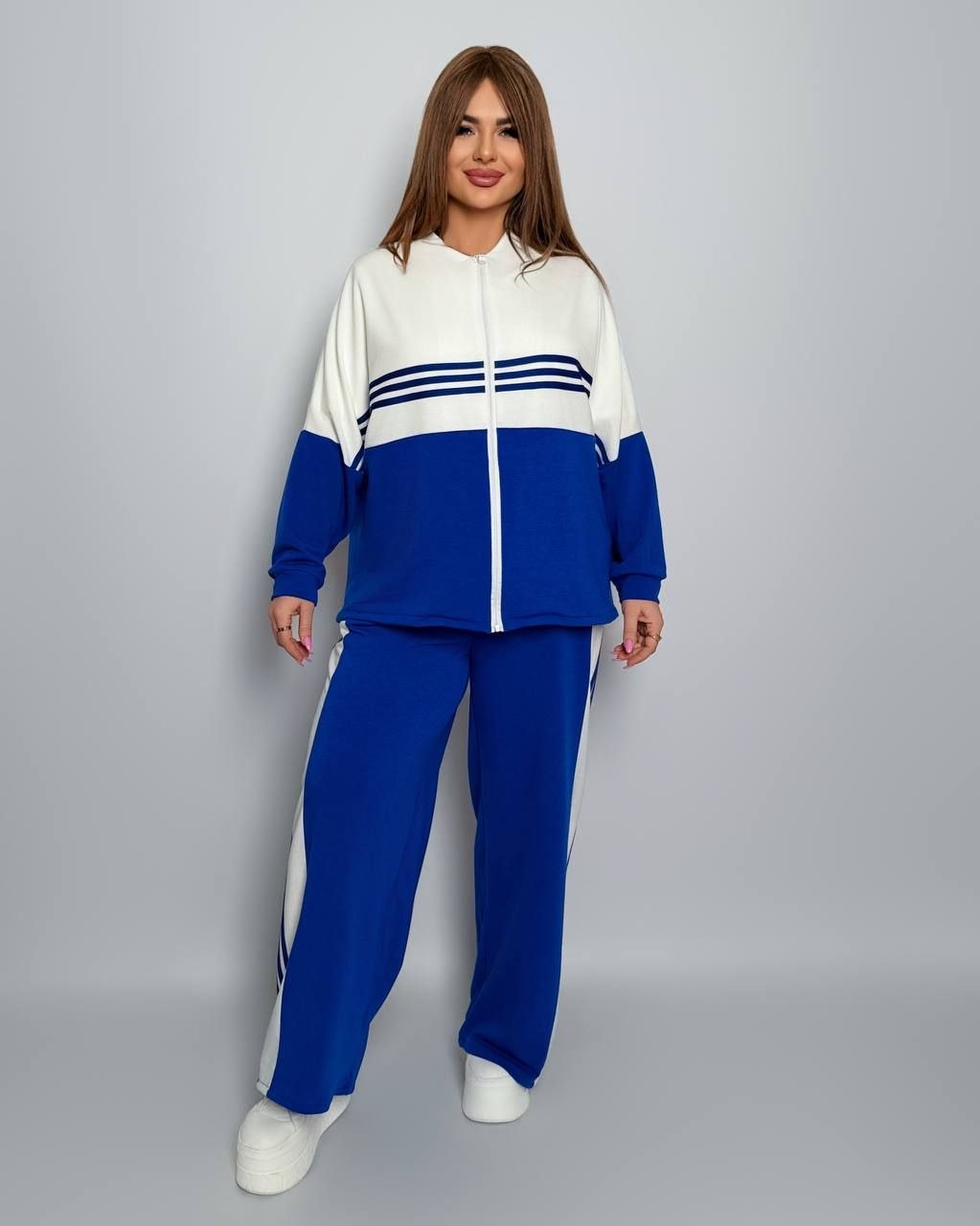 Костюм двонитка
Костюм двійка Мод № 7984
Тканина : двонитка  ( гарно тягнеться ) 
Довжина кофта : 72 см..
Довжина рукава: 75 см. ( від горловини ) 
Довжина штанів : 106 см Штани з ломпасом , з високою посадкою , пояс на гумці  , бічні кишені  . Кофта прямого покрою , з ломпасом , низ на фіксаторі ,   на блискавці  .
Артикул: GARNA-423186